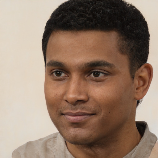 Joyful black young-adult male with short  black hair and brown eyes