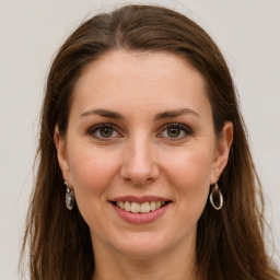 Joyful white young-adult female with long  brown hair and grey eyes