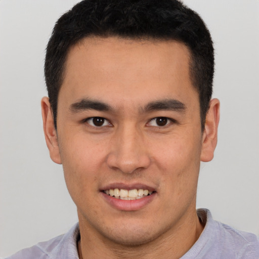 Joyful latino young-adult male with short  brown hair and brown eyes