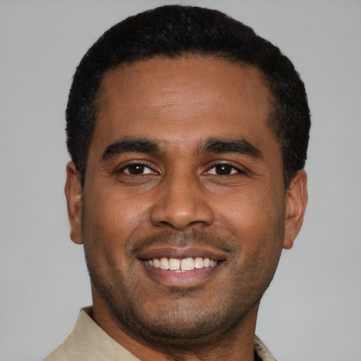 Joyful latino young-adult male with short  black hair and brown eyes