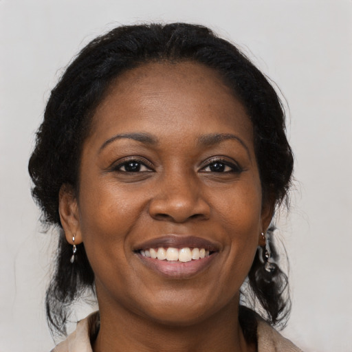 Joyful black adult female with medium  brown hair and brown eyes
