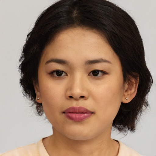 Joyful asian young-adult female with medium  brown hair and brown eyes