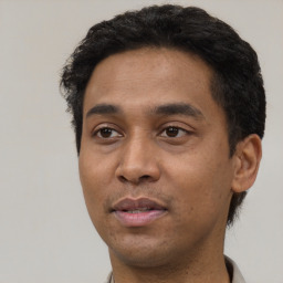 Joyful latino young-adult male with short  black hair and brown eyes