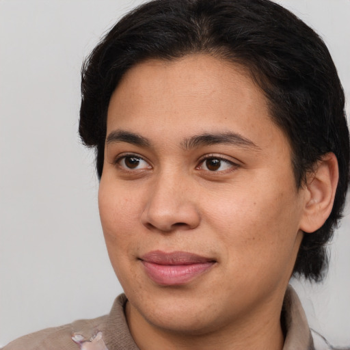 Joyful latino young-adult female with medium  brown hair and brown eyes