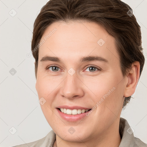 Joyful white young-adult female with short  brown hair and grey eyes