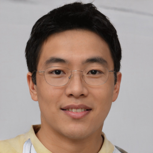 Joyful asian young-adult male with short  brown hair and brown eyes