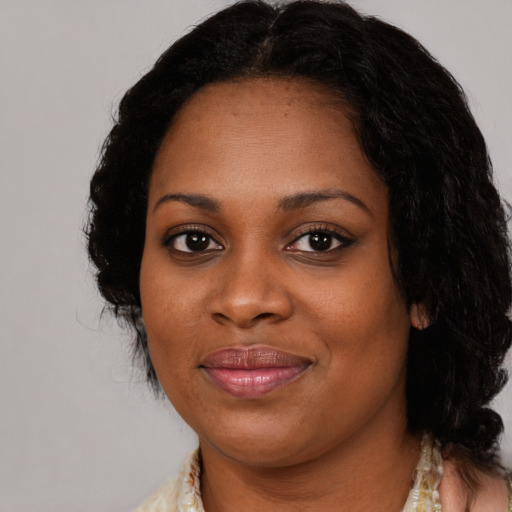 Joyful black young-adult female with medium  black hair and brown eyes