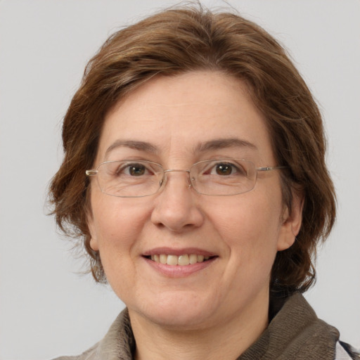 Joyful white adult female with medium  brown hair and grey eyes