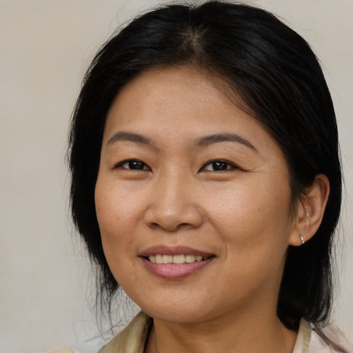 Joyful asian adult female with medium  brown hair and brown eyes