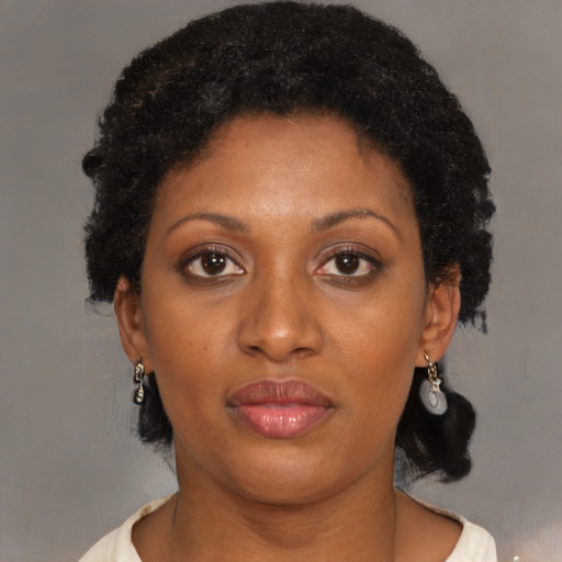 Joyful black adult female with short  brown hair and brown eyes