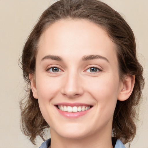 Joyful white young-adult female with medium  brown hair and green eyes