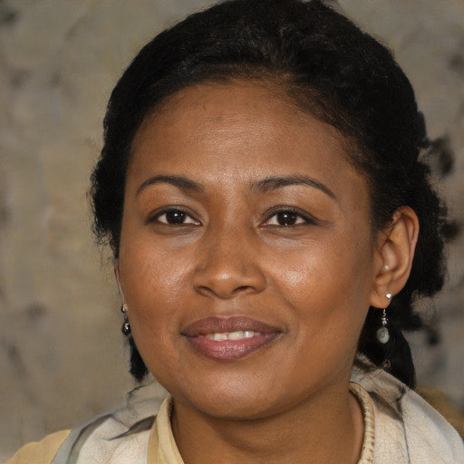 Joyful latino adult female with medium  brown hair and brown eyes