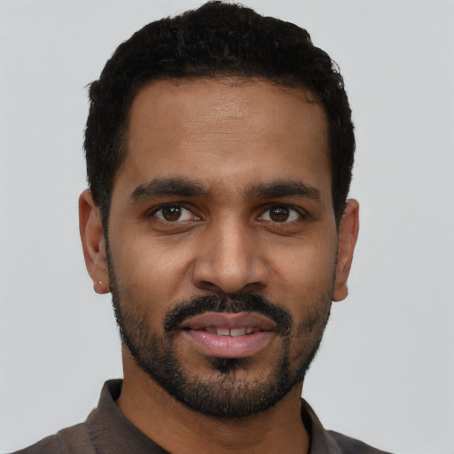 Joyful black young-adult male with short  black hair and brown eyes