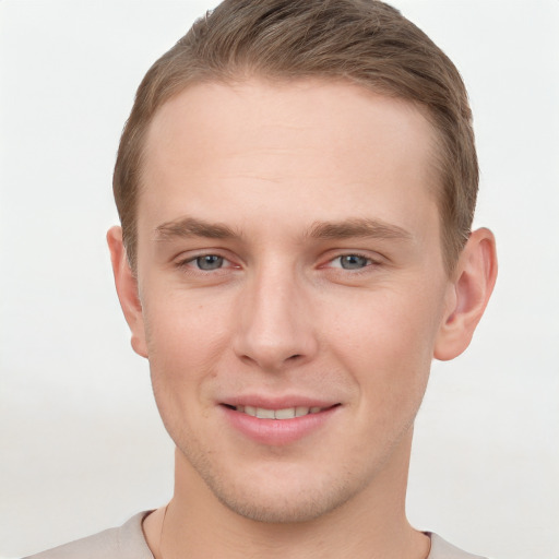 Joyful white young-adult male with short  brown hair and grey eyes