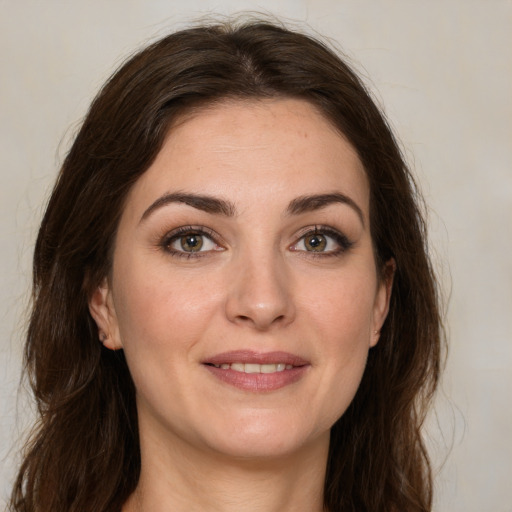 Joyful white young-adult female with long  brown hair and green eyes