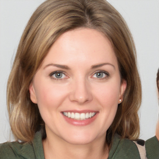 Joyful white young-adult female with medium  brown hair and green eyes