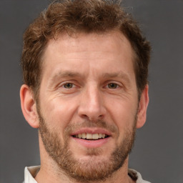 Joyful white adult male with short  brown hair and brown eyes