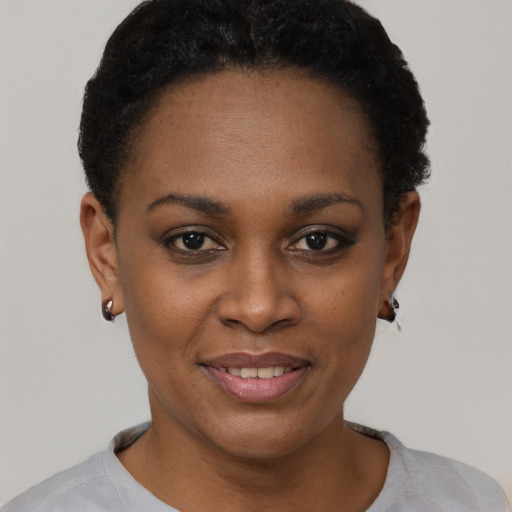 Joyful black young-adult female with short  black hair and brown eyes