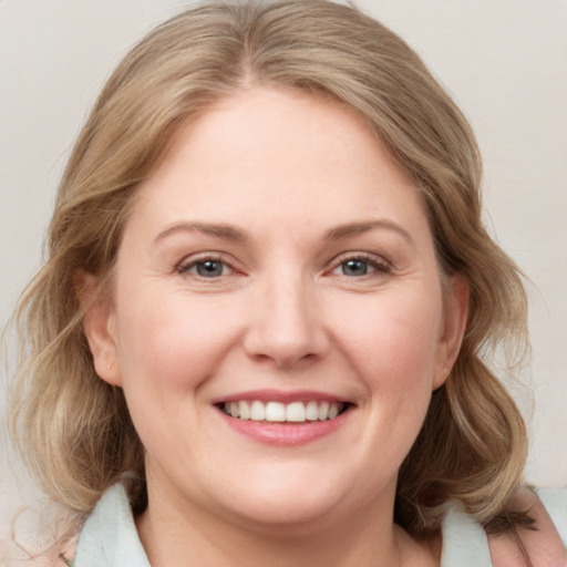 Joyful white young-adult female with medium  brown hair and blue eyes