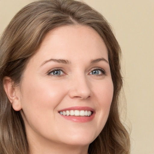 Joyful white young-adult female with long  brown hair and green eyes