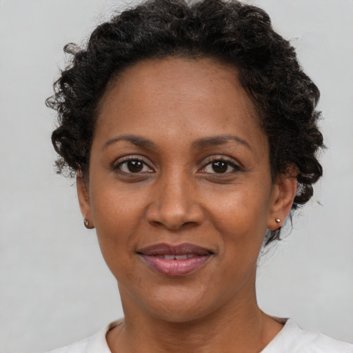 Joyful black adult female with short  brown hair and brown eyes