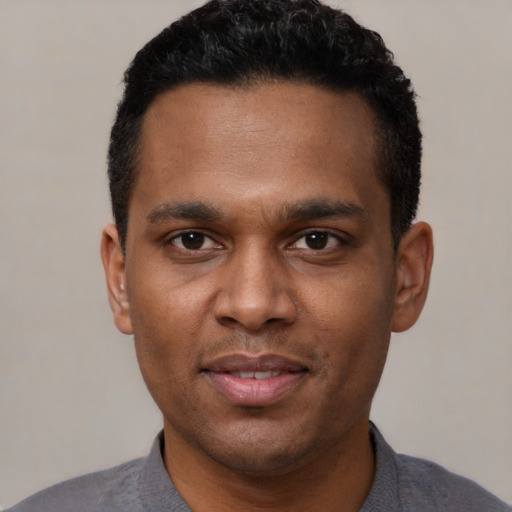 Joyful latino young-adult male with short  black hair and brown eyes