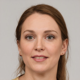 Joyful white young-adult female with medium  brown hair and grey eyes