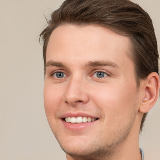 Joyful white young-adult male with short  brown hair and grey eyes