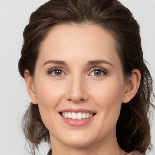 Joyful white young-adult female with medium  brown hair and grey eyes