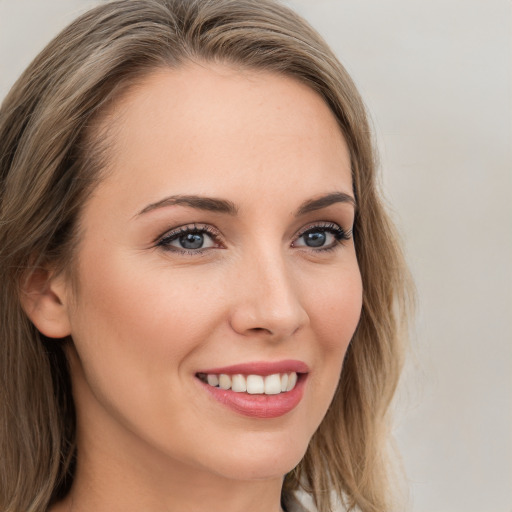 Joyful white young-adult female with long  brown hair and grey eyes