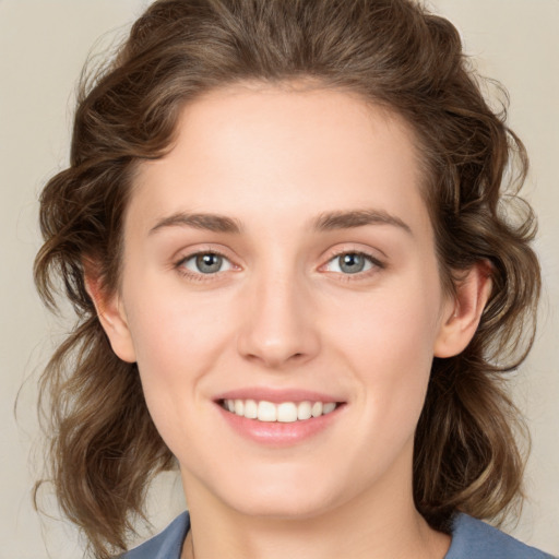 Joyful white young-adult female with medium  brown hair and green eyes