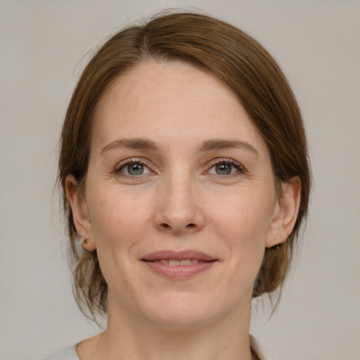 Joyful white young-adult female with medium  brown hair and grey eyes