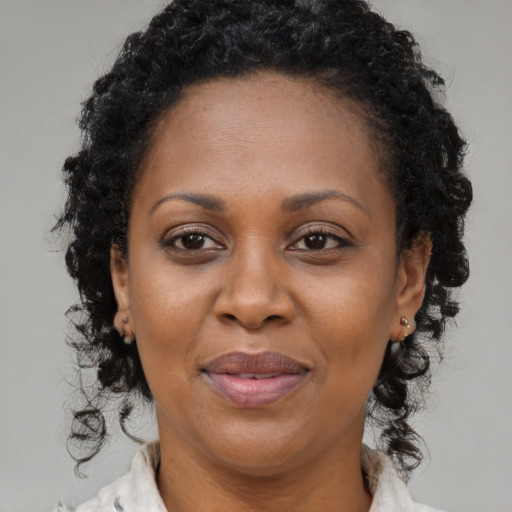 Joyful black adult female with medium  brown hair and brown eyes