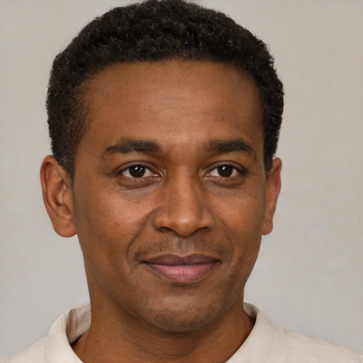 Joyful black adult male with short  brown hair and brown eyes