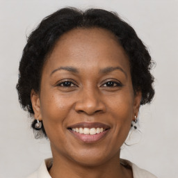 Joyful black adult female with medium  brown hair and brown eyes