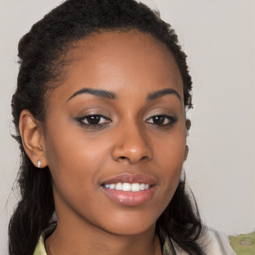 Joyful black young-adult female with long  brown hair and brown eyes