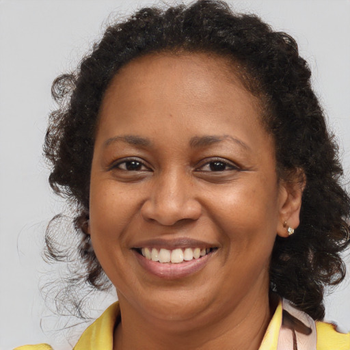 Joyful black adult female with medium  brown hair and brown eyes