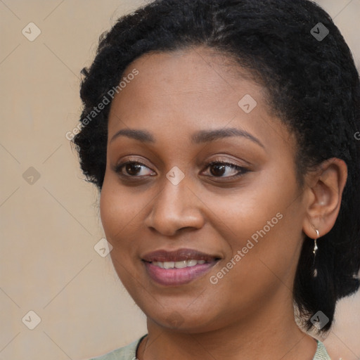 Joyful black young-adult female with long  black hair and brown eyes