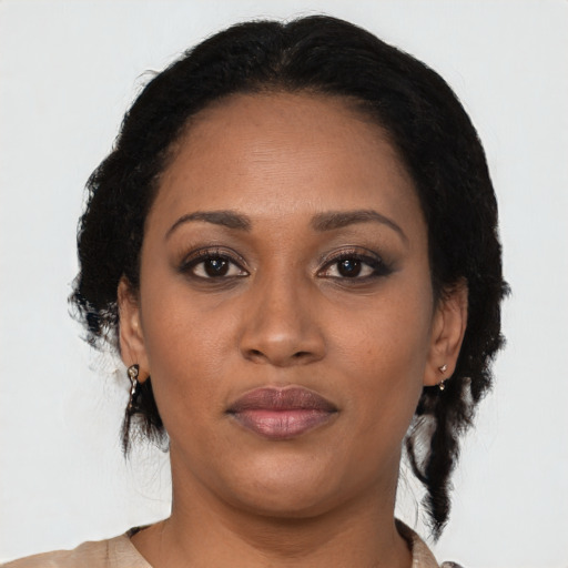 Joyful black adult female with medium  black hair and brown eyes