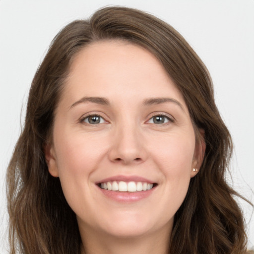 Joyful white young-adult female with long  brown hair and grey eyes