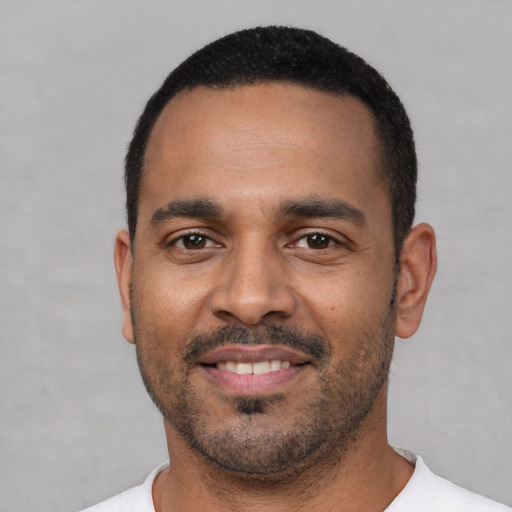 Joyful latino young-adult male with short  black hair and brown eyes