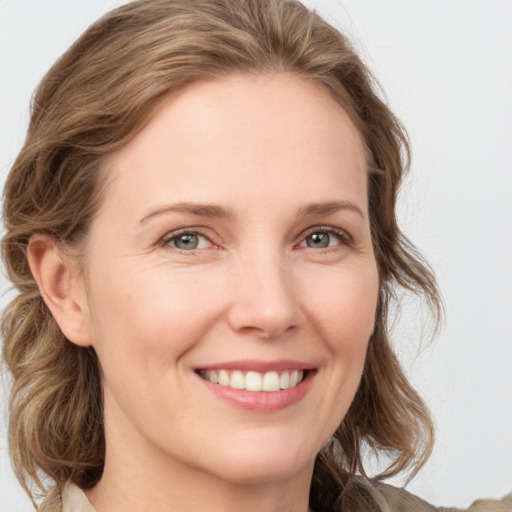 Joyful white young-adult female with medium  brown hair and green eyes