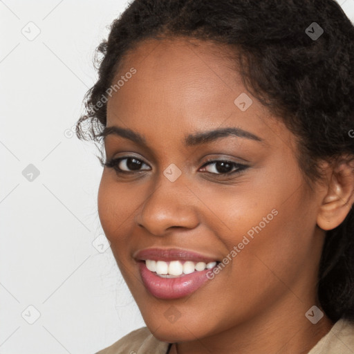 Joyful black young-adult female with long  brown hair and brown eyes