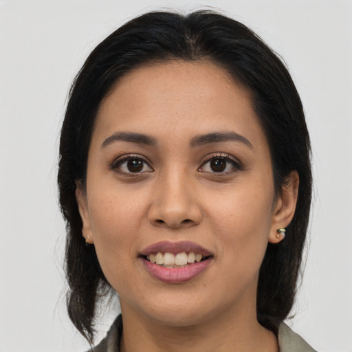 Joyful latino young-adult female with long  brown hair and brown eyes