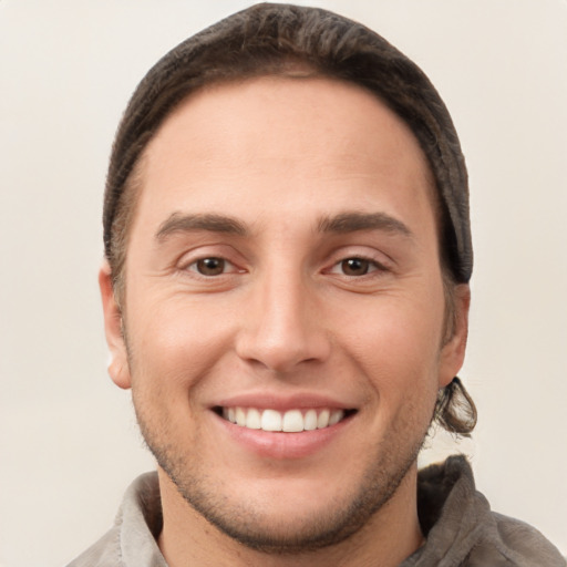 Joyful white young-adult male with short  brown hair and brown eyes