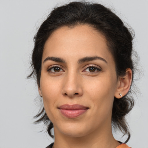 Joyful latino young-adult female with medium  brown hair and brown eyes