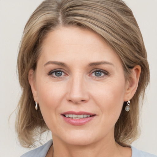 Joyful white adult female with medium  brown hair and grey eyes