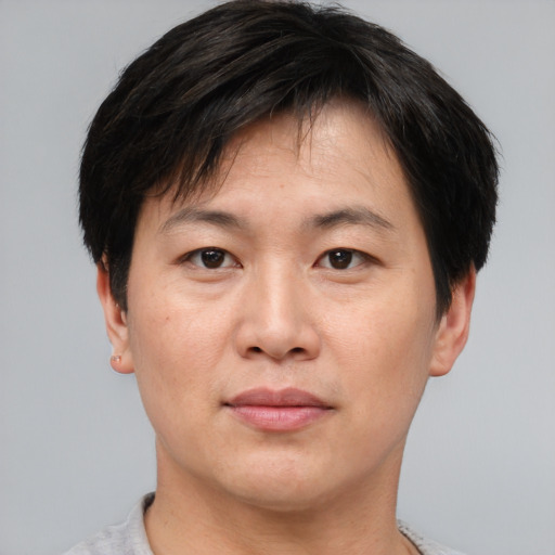 Joyful asian adult male with short  brown hair and brown eyes