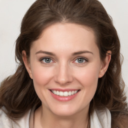 Joyful white young-adult female with medium  brown hair and grey eyes