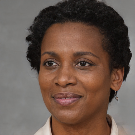 Joyful black adult female with short  brown hair and brown eyes